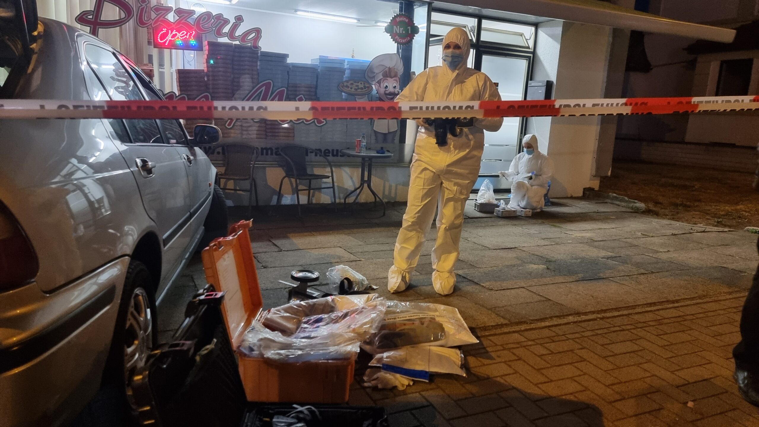 Polizeibeamte bei der Spurensicherung vor einer Pizzeria in Neustadt am Rübenberge.