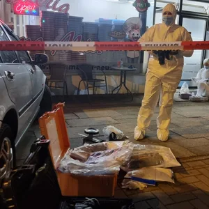 Polizeibeamte bei der Spurensicherung vor einer Pizzeria in Neustadt am Rübenberge.