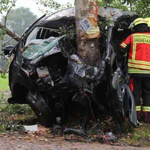 Feuerwehrkräfte am völlig deformierten Ford.
