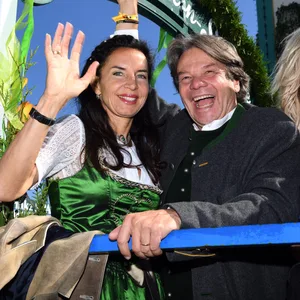 Das Wirtsehepaar Michael und Clarissa Käfer (l) winkt beim Einzug der Festwirte aus dem Wagen des Käferzelts.