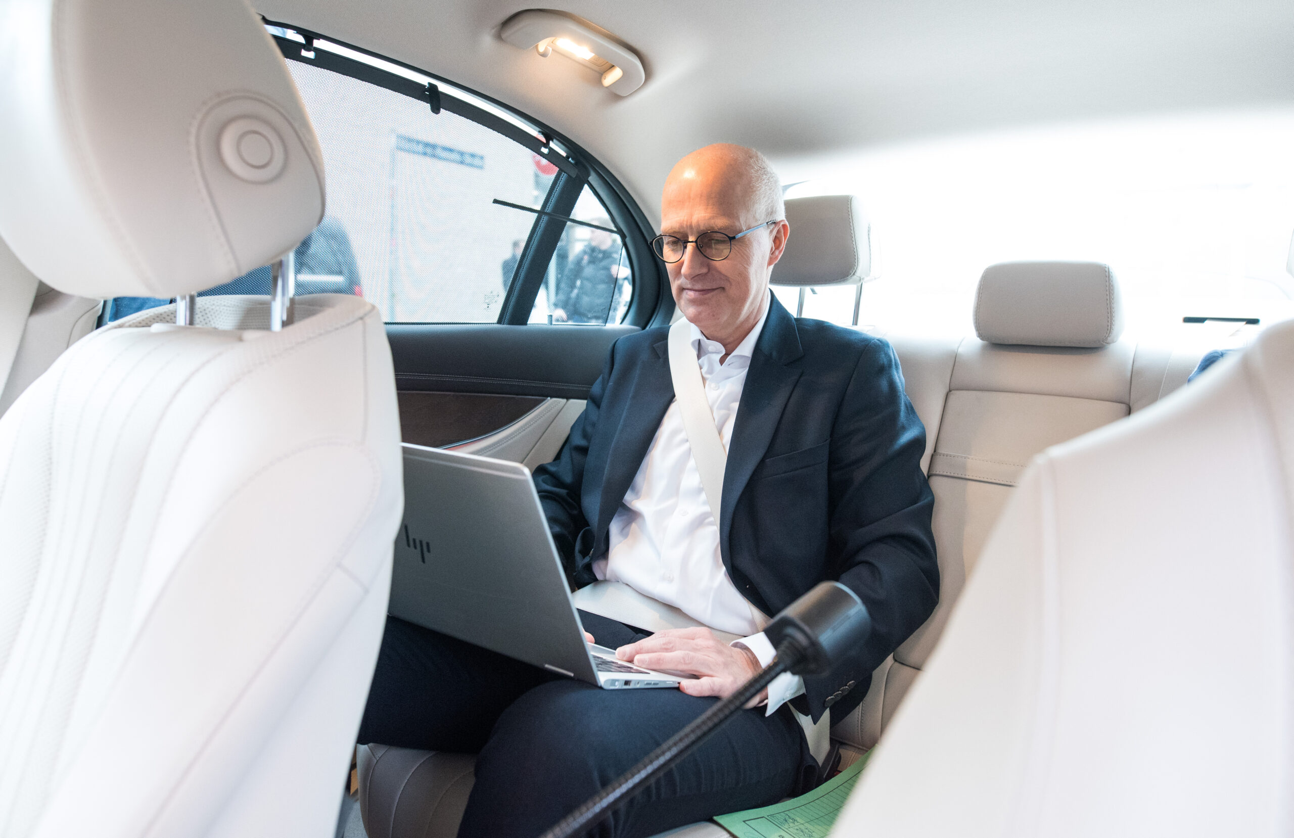 Bürgermeister Peter Tschentscher (SPD) mit Laptop in seinem Dienstwagen.
