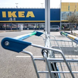 Blick auf ein gelb-blaues Ikea-Möbelhaus, davor ein Parkplatz mit Autos