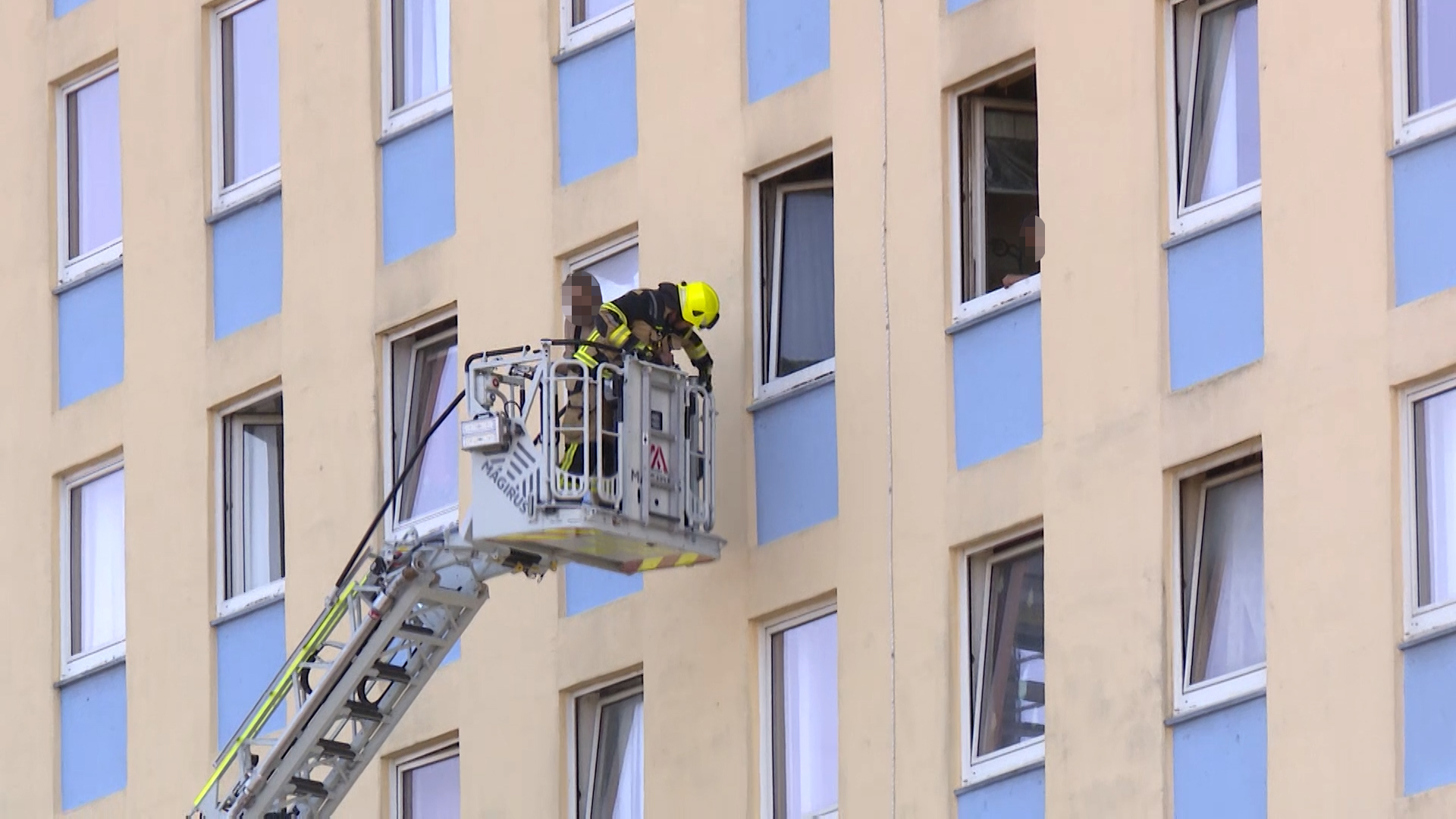 Über eine Drehleiter wird einer der Bewohner von der Feuerwehr gerettet.