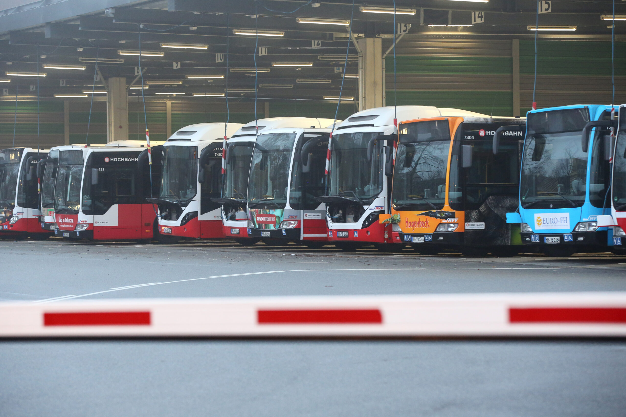 Busse stehen am Morgen hinter einer Schranke