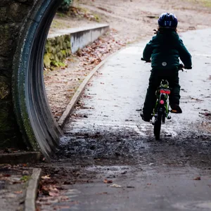 Ein Kind radelt durch einen Tunnel in einem Park. (Symbolbild)