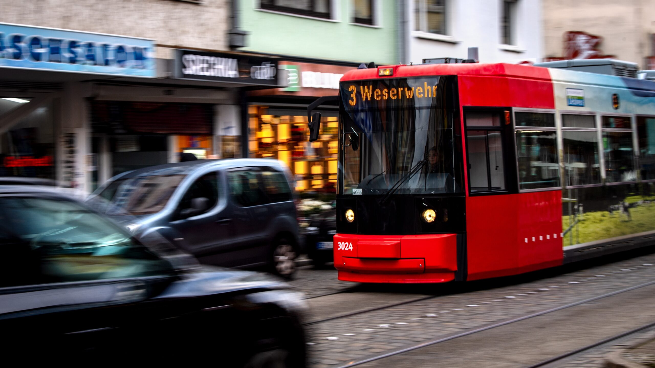 Eine Straßenbahn fährt zwischen Autos durch die Innenstadt.