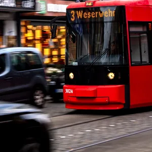 Eine Straßenbahn fährt zwischen Autos durch die Innenstadt.