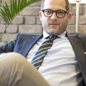 Reichelt sitzt im Anzug auf einer Couch