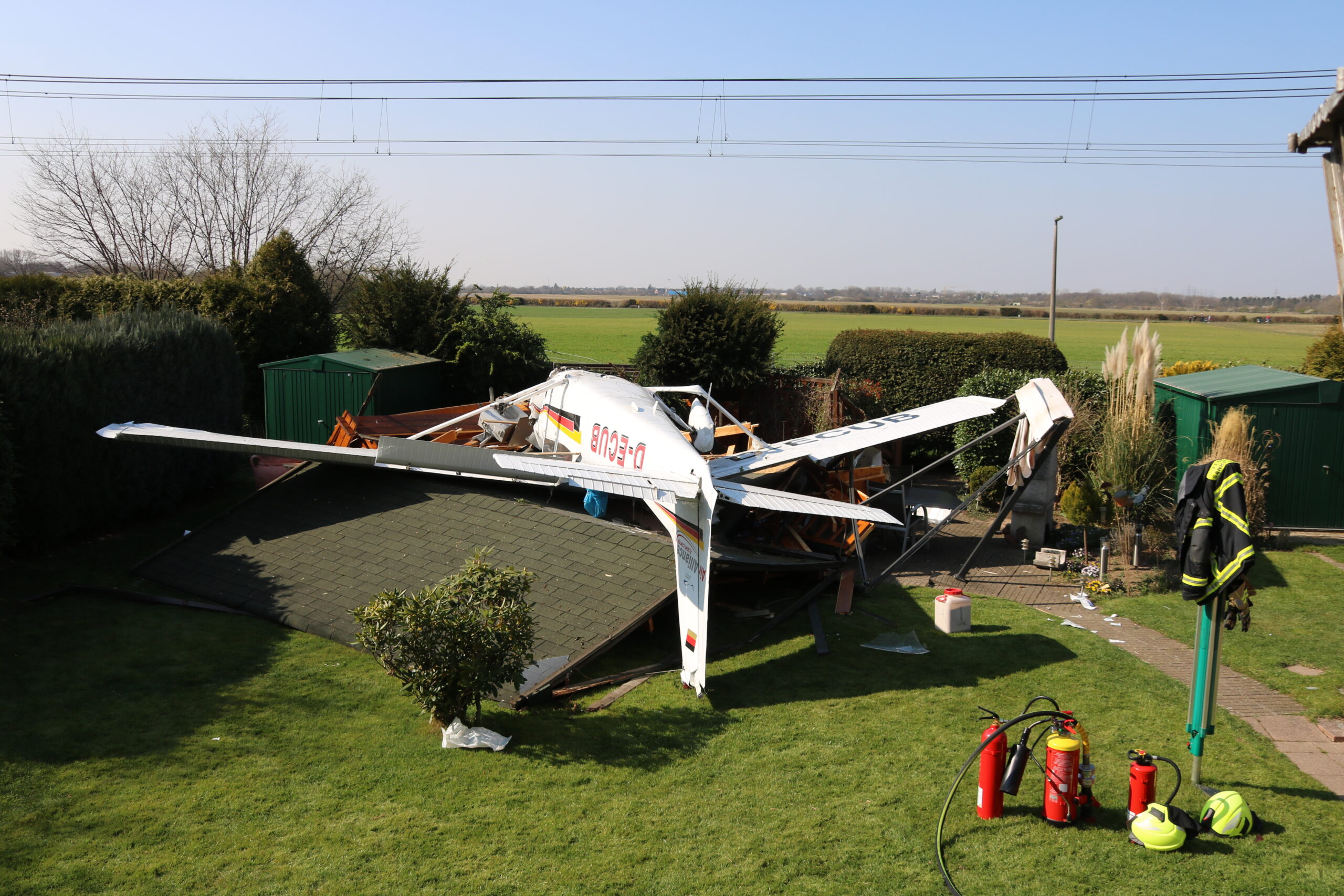 Ein verunglücktes Kleinflugzeug liegt in einem Garten in Sankt Augustin auf dem Dach.