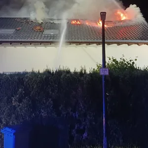 Einsatzkräfte der Feuerwehr sind bei einem Brand eines Einfamilienhauses im Einsatz.