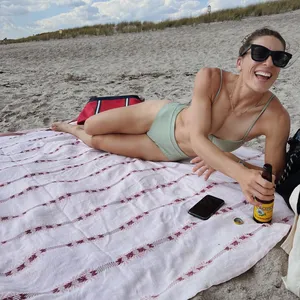 Andrea Petkovic relaxt am Strand mit einem Kaltgetränk in der Hand.