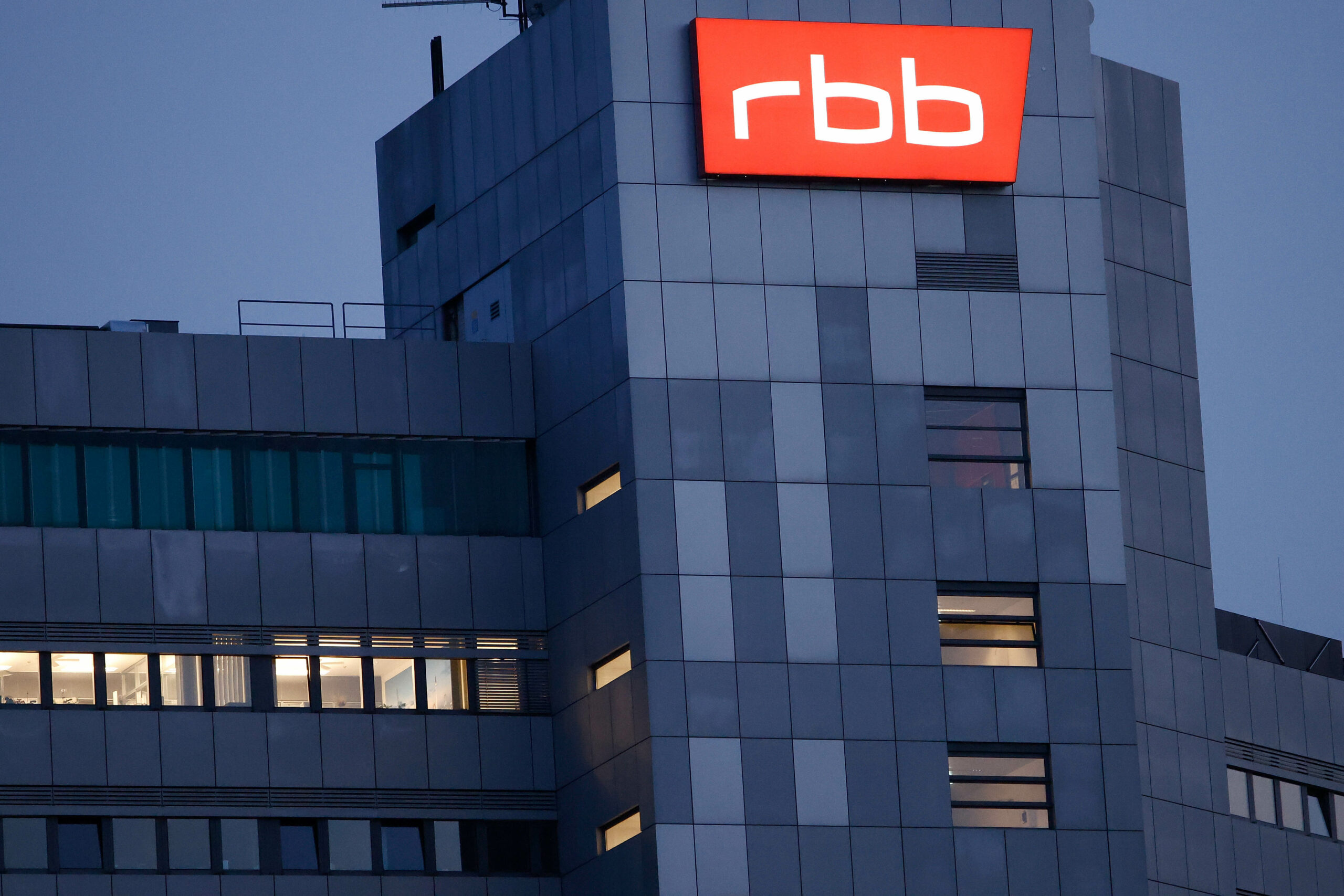 Das beleuchtete Logo des Senders Rundfunk Berlin-Brandenburg (RBB) ist an der Fassade am Sitz des Senders an der Masurenallee angebracht.
