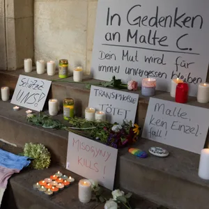 Eine Frau entzündet eine Kerze in Gedenken an Malte C..