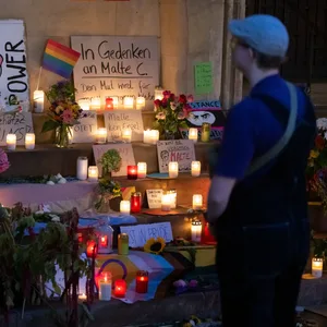 Blumen und Kerzen liegen an der Gedenkstätte für Malte C. auf den Stufen des historischen Rathauses in Münster.