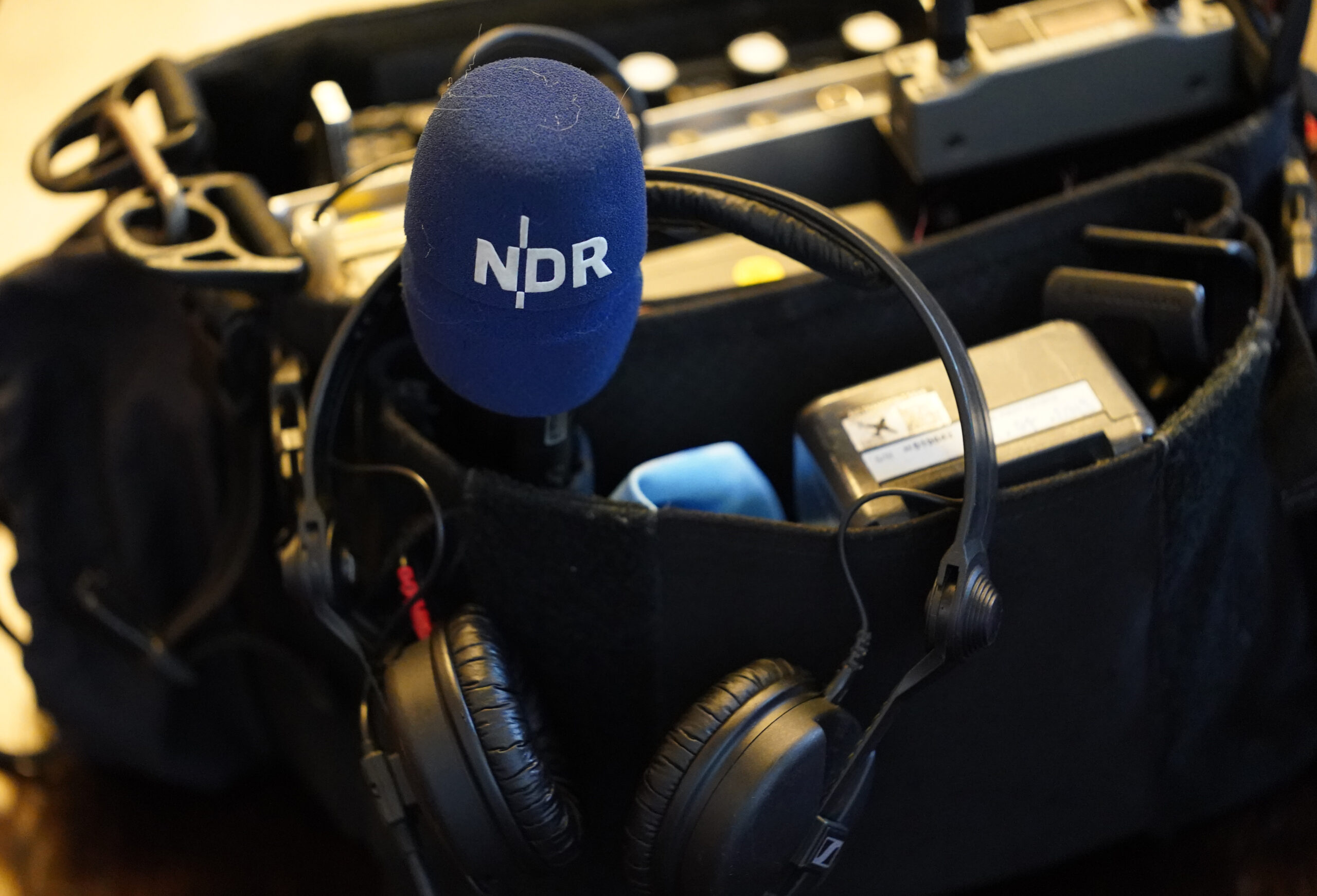 Das NDR-Logo ist auf einem Mikrofon während eines Medientermins zu sehen.