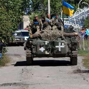 Ukrainische Soldaten fahren mit einem Militärfahrzeug.