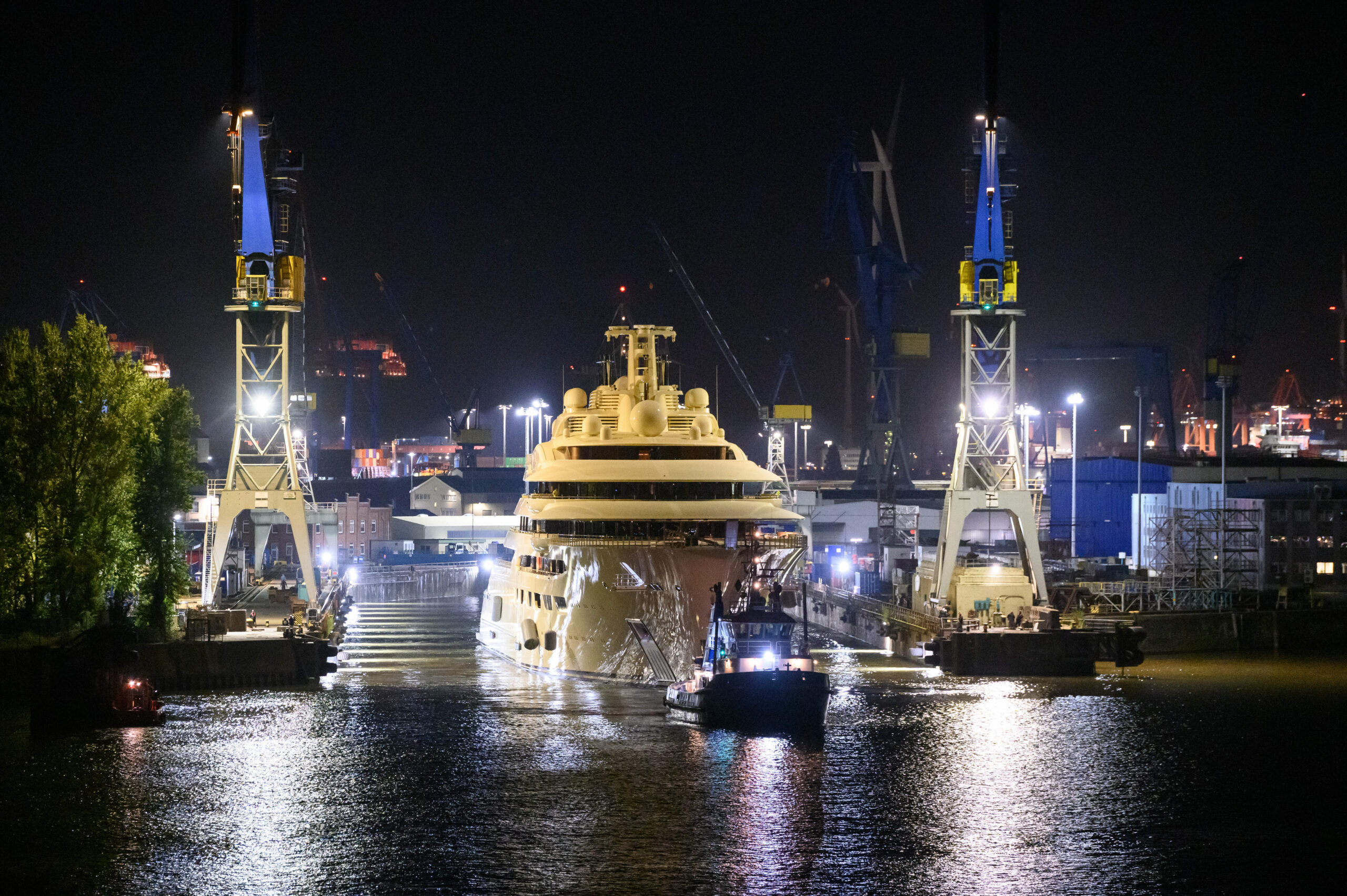 Die Luxusjacht „Dilbar“ wird von Schleppern aus dem gefluteten Trockendock der Werft Blohm + Voss auf die Elbe vor den Landungsbrücken gezogen.