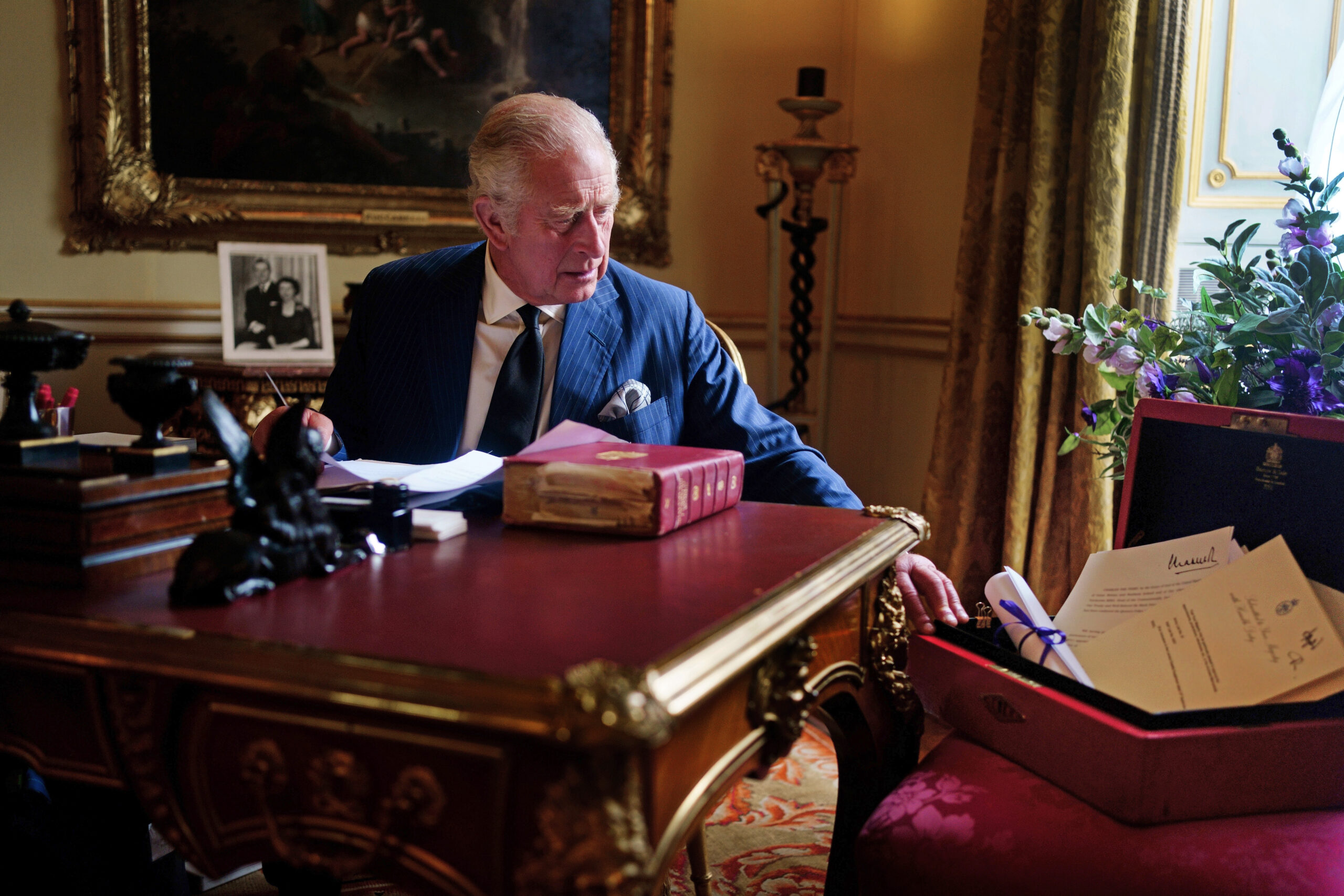 König Charles III. sitzt bei der Erledigung offizieller Regierungsaufgaben aus seiner roten Box im Buckingham Palast.