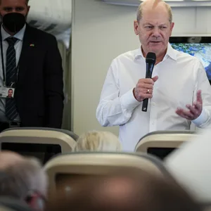 Olaf Scholz (SPD) spricht auf dem Flug nach Saudi-Arabien mit den mitreisenden Journalisten.