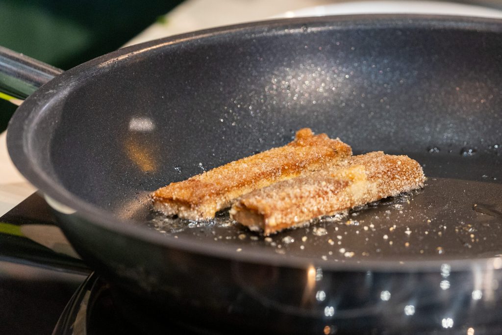 Panierte Fischstäbchen ohne Fisch, welche aus Tofu mit Algenblatt-Mantel bestehen, liegen auf der Messe Biofach während einer Koch-Show zu veganem Fischersatz in einer Pfanne.