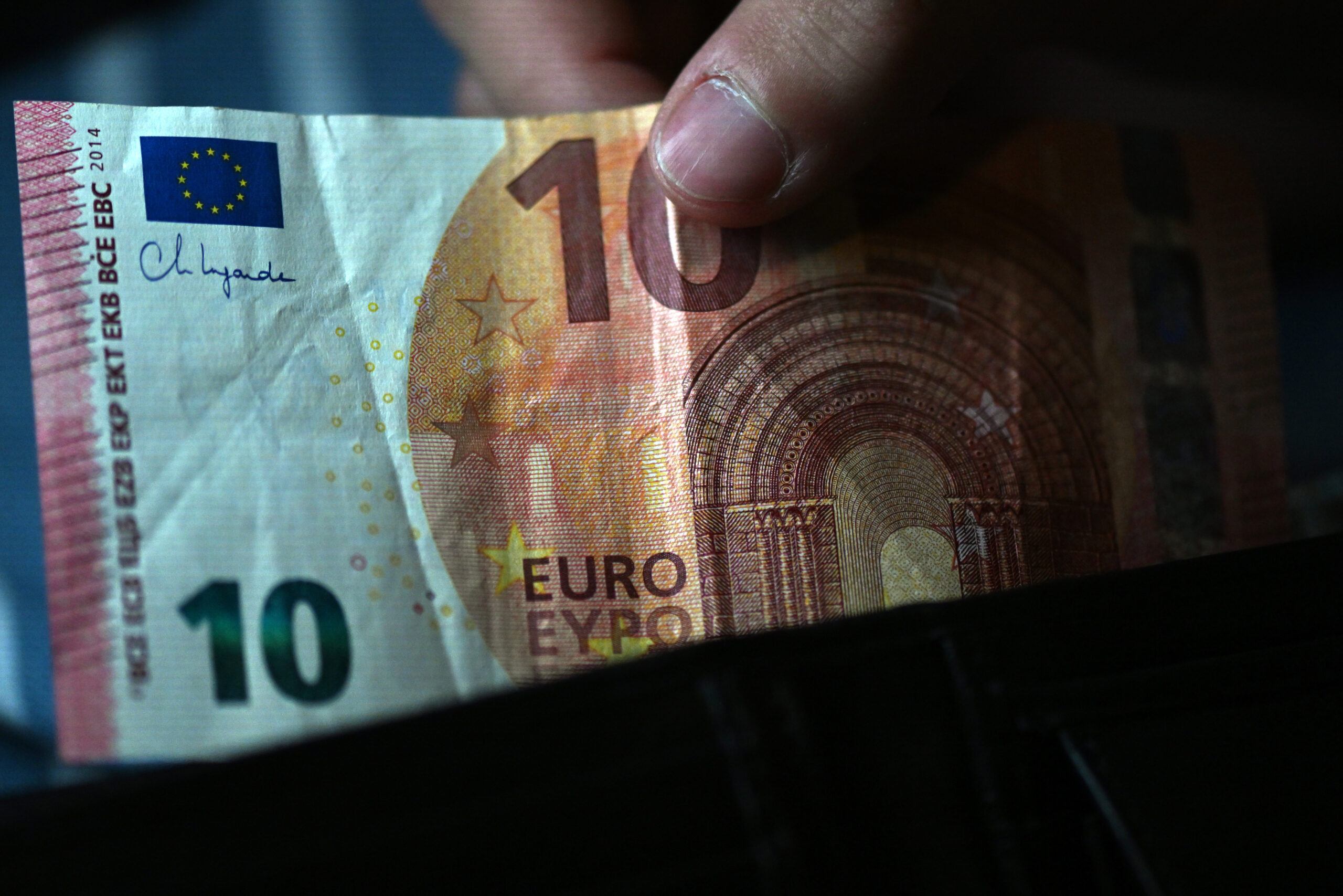 Ein Mann nimmt einen Zehn-Euro-Schein aus einem Portemonaie. (Symbolbild)