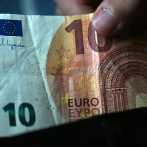 Ein Mann nimmt einen Zehn-Euro-Schein aus einem Portemonaie. (Symbolbild)