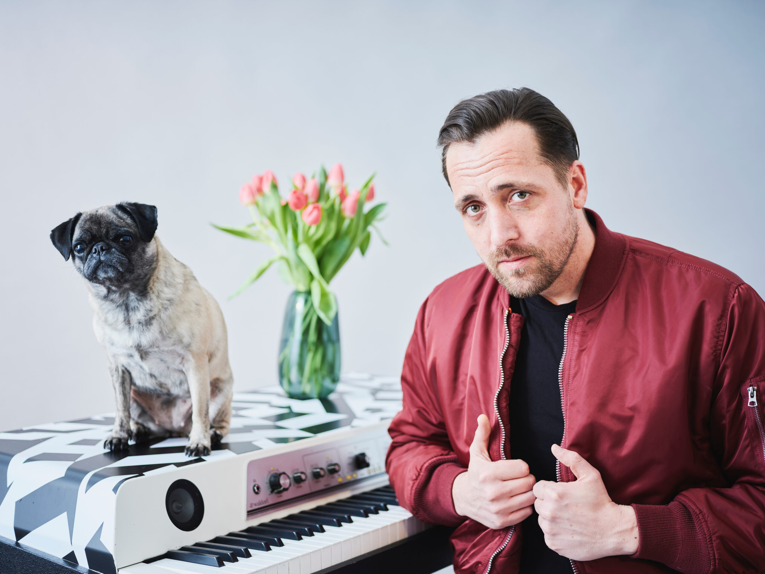Rechts sitzt Danger Dan, links, auf dem E-Klavier, ein Hund