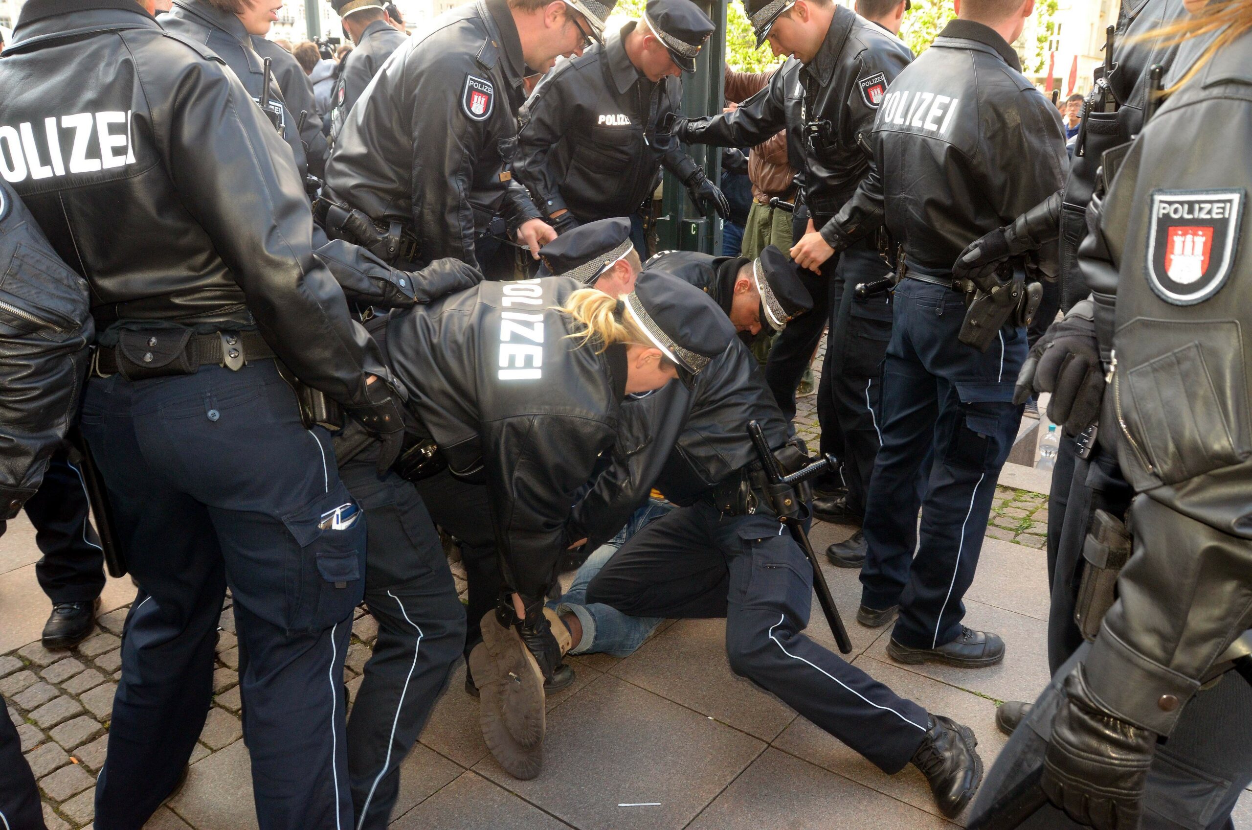 Polizisten nehmen bei einem Protest einen Demonstranten in Gewahrsam.