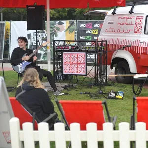 Ein rot-weißes Mopo-Auto, ein DJ-Pult und ein Musiker sind auf dem Heiligengeistfeld zu sehen