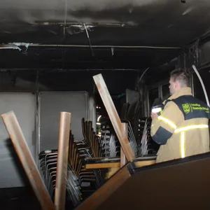 Feuerwehrkräfte in dem stark beschädigten Container.