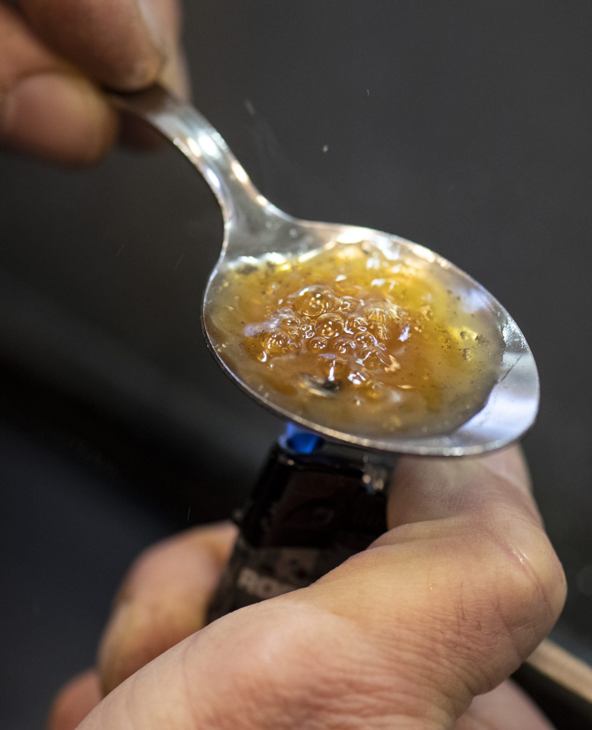 Ein Drogensüchtiger kocht sich in einem sogenannten Druckraum unter Aufsicht und hygienischen Bedingungen eine Portion Heroin in einem Löffel auf (Symbolbild).