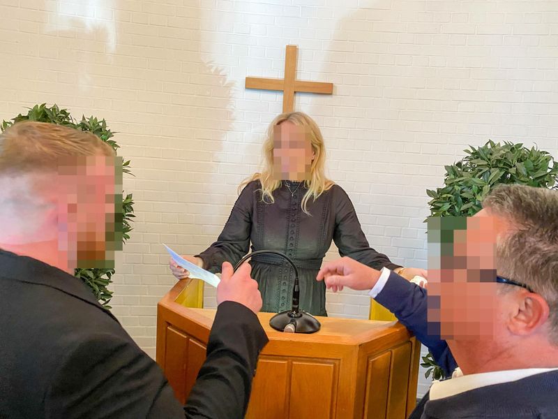 Bodyguards decken das Mikrofon mit ihren Händen ab und behindern eine Angehörige der Familie bei ihrer Rede.