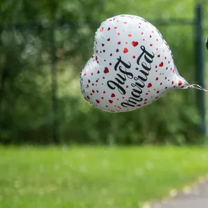 Ein Luftballon in Herzform mit der Aufschrift „Just Married“ ist an einem Brautauto befestigt. (Symbolbild)