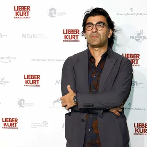 Akin steht vor einer Wand, auf der man den Filmtitel geschrieben sieht