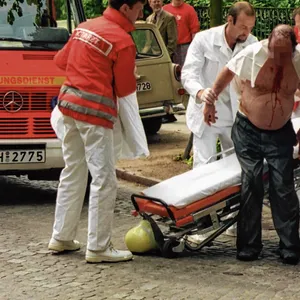 Nach dem Mordanschlag wird Dr. Jens-Peter L. (78) an der Magdalenenstraße von Rettungs-Sanitätern versorgt.