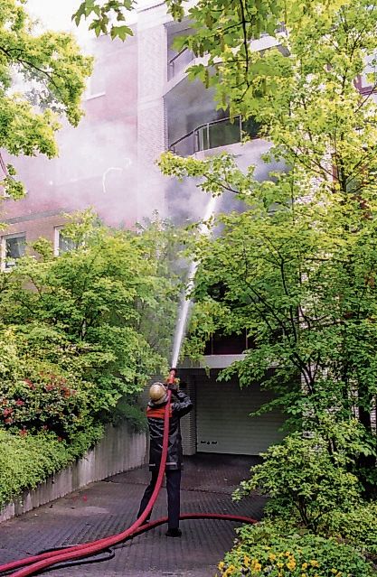 Ein Feuerwehrmann löscht den Brand in der Wohnung in der Magdalenenstraße 66.