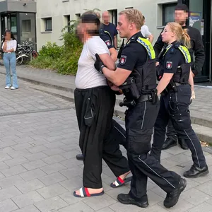Polizeibeamte führen einen Mann ab