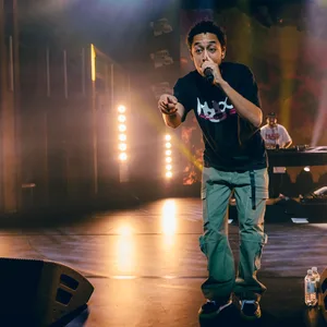 Loyle Carner gestikuliert Richtung Publikum