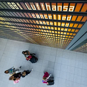 Die Worte "Lufthansa" und "cancelled" sind an einer Anzeigetafel am Flughafen zu lesen.