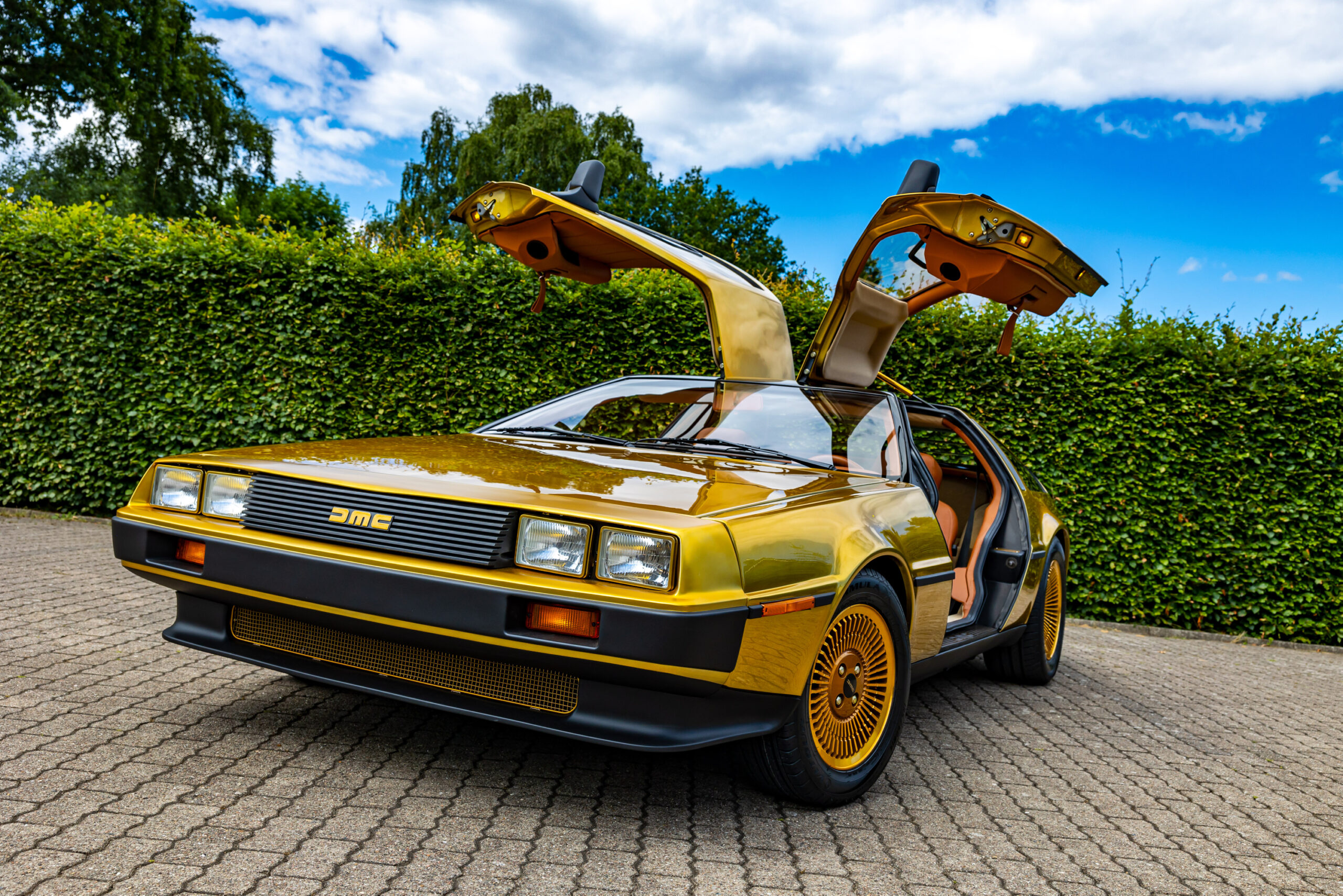 Ein goldener DeLorean mit offenen Türen.
