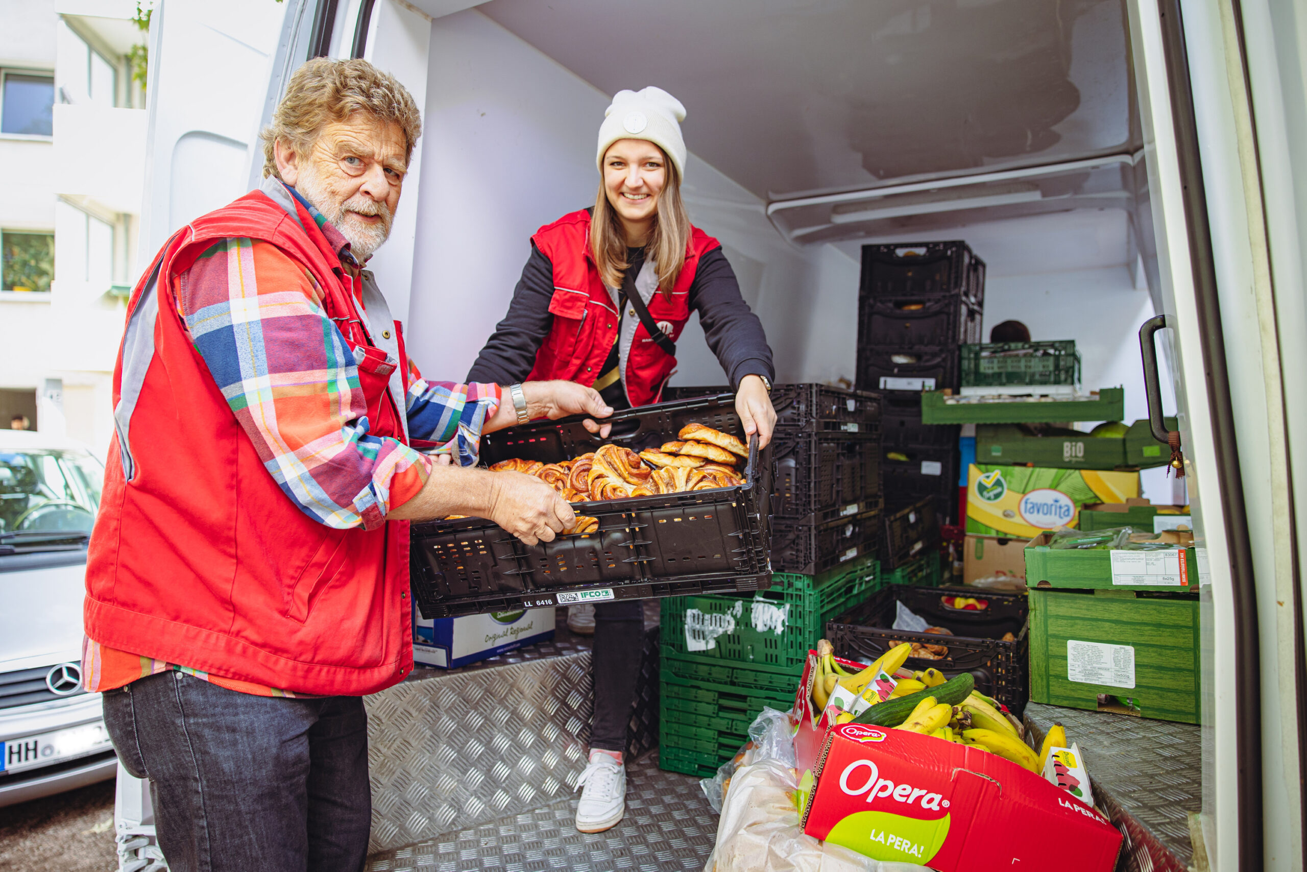 Tafelmitarbeiter Birger Warncke (73) und Foodloose-Mitarbeiterin Kira Loy (27) fahren zusammen Lebensmittel aus.