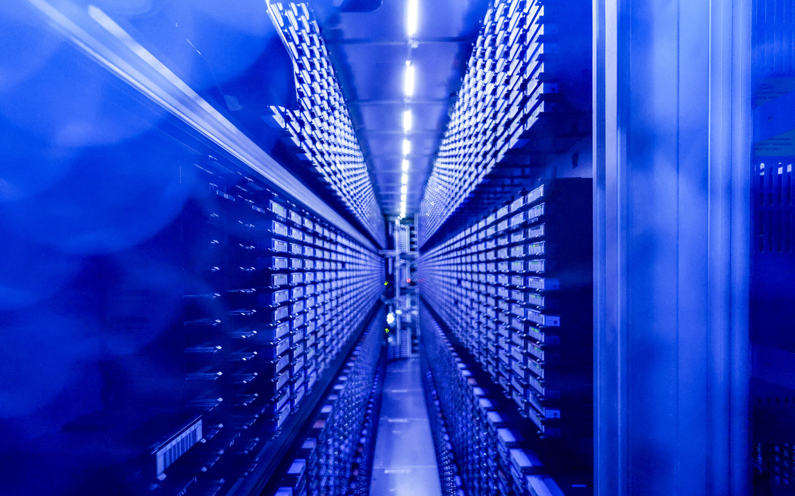 Festplattenstapel werden im neu eingeweihten Supercomputer "Levante" im DKRZ von blauen Lichtern illuminiert.