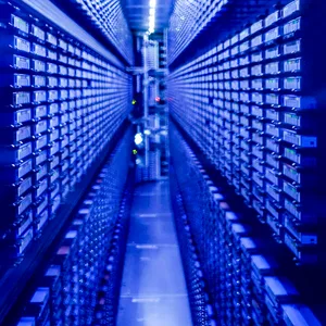 Festplattenstapel werden im neu eingeweihten Supercomputer "Levante" im DKRZ von blauen Lichtern illuminiert.