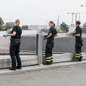 Feuerwehrleute bauen eine Flutschutzmauer auf