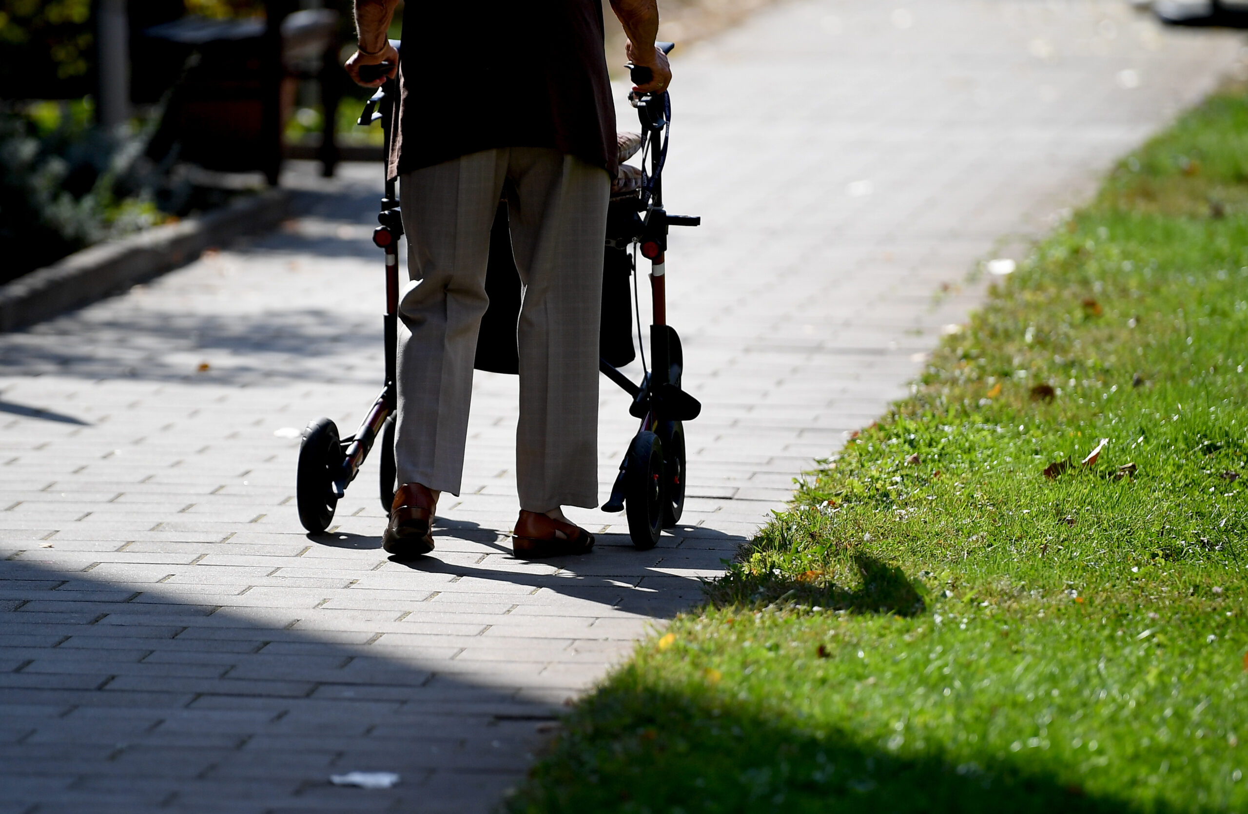 Eine 90-Jährige mit Rollator wurde von einem Auto angefahren und ist an den Folgen gestorben. (Symbolbild: eine Seniorin mit Rollator auf einem Gehweg)