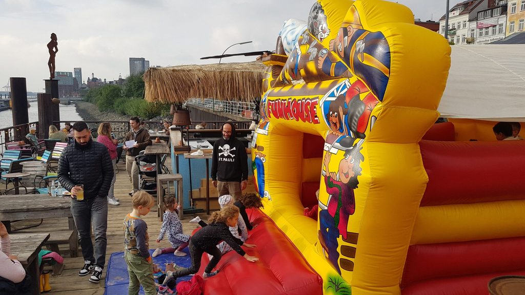 Kinder klettern in eine Hüpfburg.