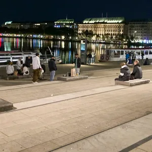 Menschen sitzen am Abend am Jungfernstieg in Hamburg