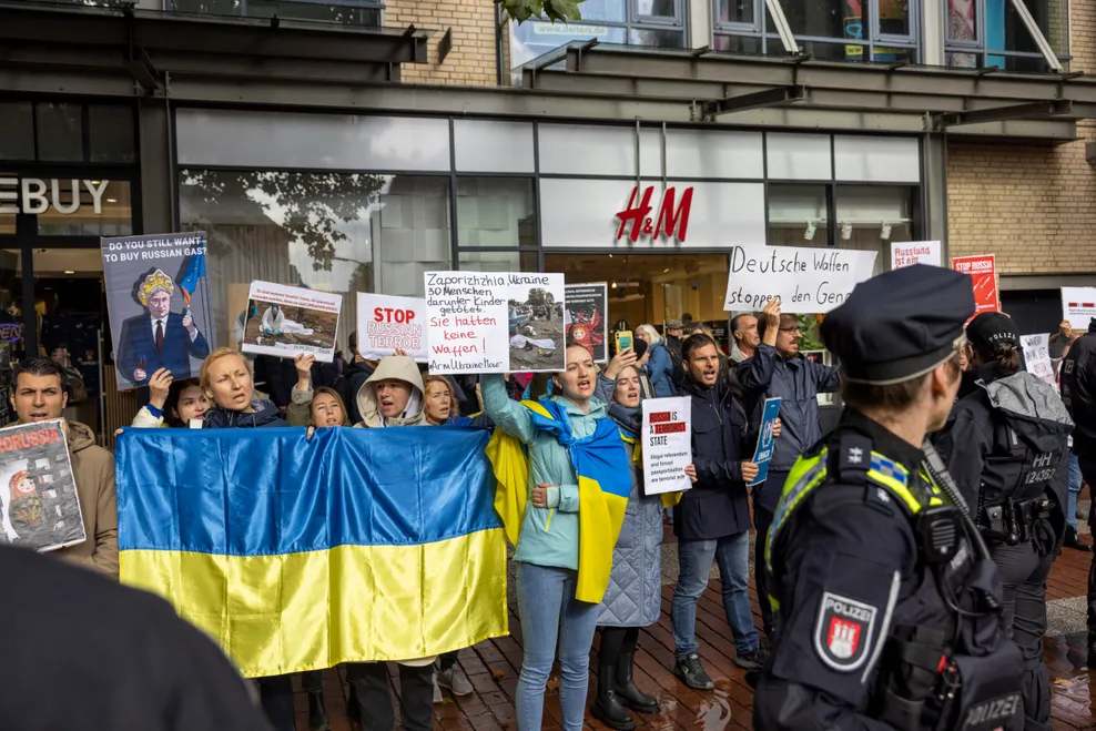 „Stop Russian Terror“ und „Deutsche Waffen stoppen den Genozid“ steht auf den Plakaten der Gegendemonstranten.