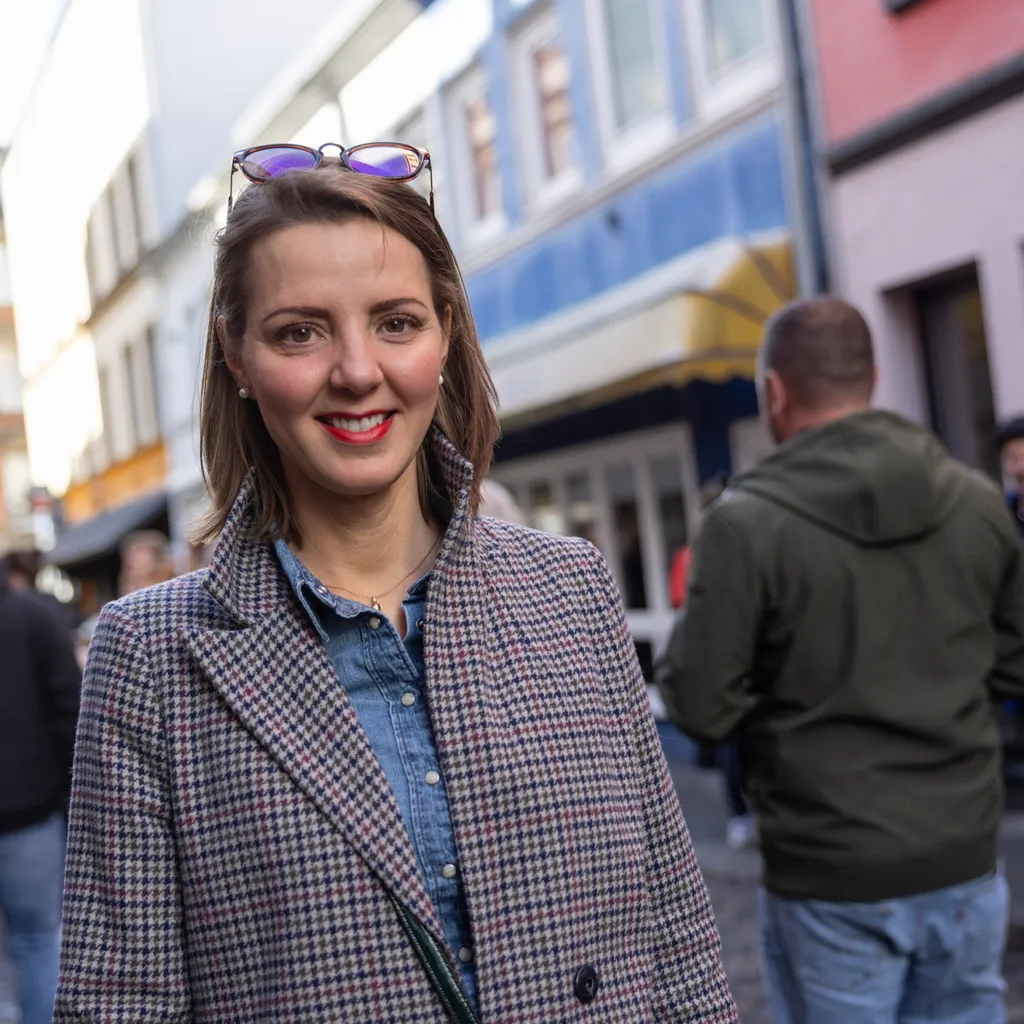 Eine Frau steht in der Herbertstraße und lächelt