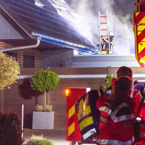 Feuerwehrkräfte nehmen auch Teile der Dach-Verkleidung ab, um zu schauen, ob sich das Feuer dorthin ausgebreitet hat.